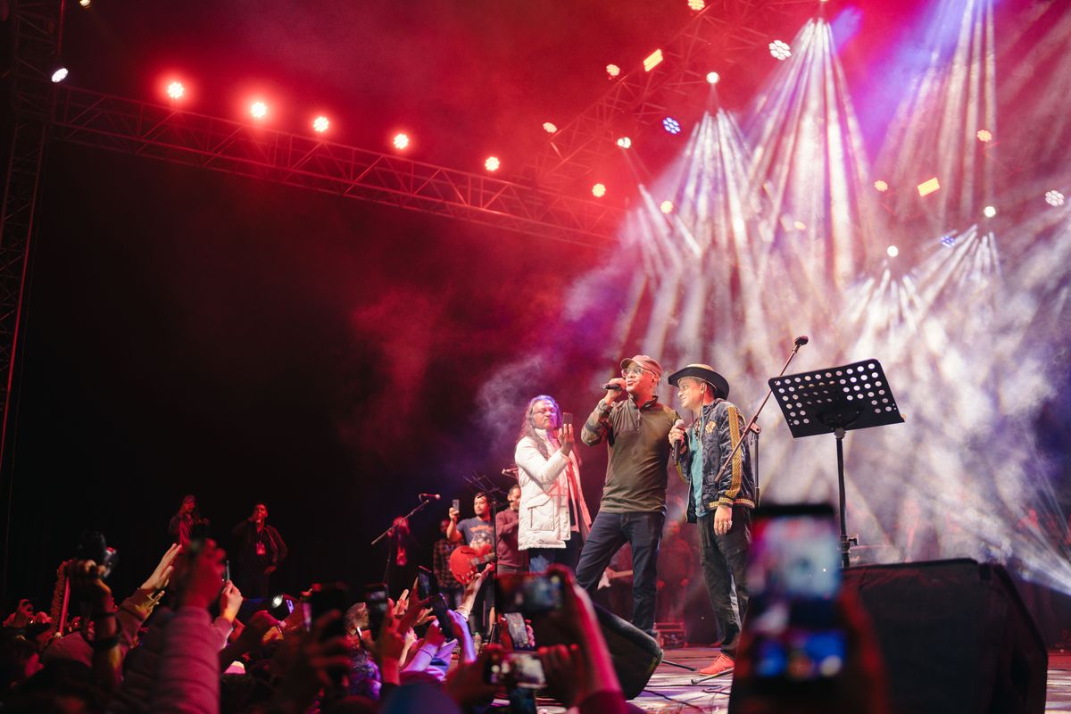 Performers on stage under red lights